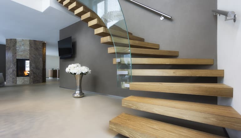 Escalera interior de madera maciza con diseño moderno, integrada en un espacio de estilo contemporáneo.